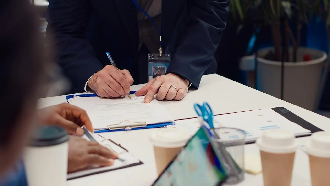 Unternehmer unterzeichnen einen neuen Partnerschaftsvertrag zwischen ihren Firmen.